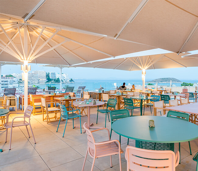 Pérgola en terraza de restaurante por la noche delante del puerto