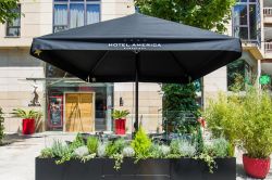 Parasol ibiza d negro con jardinera en terraza de bar
