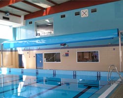 Instalación elevada de un enrollador con cobertor replegado en piscina