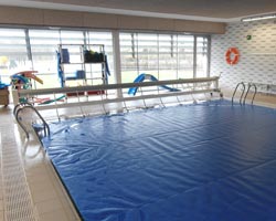 Instalación móvil de un cobertor deplegado en piscina interior