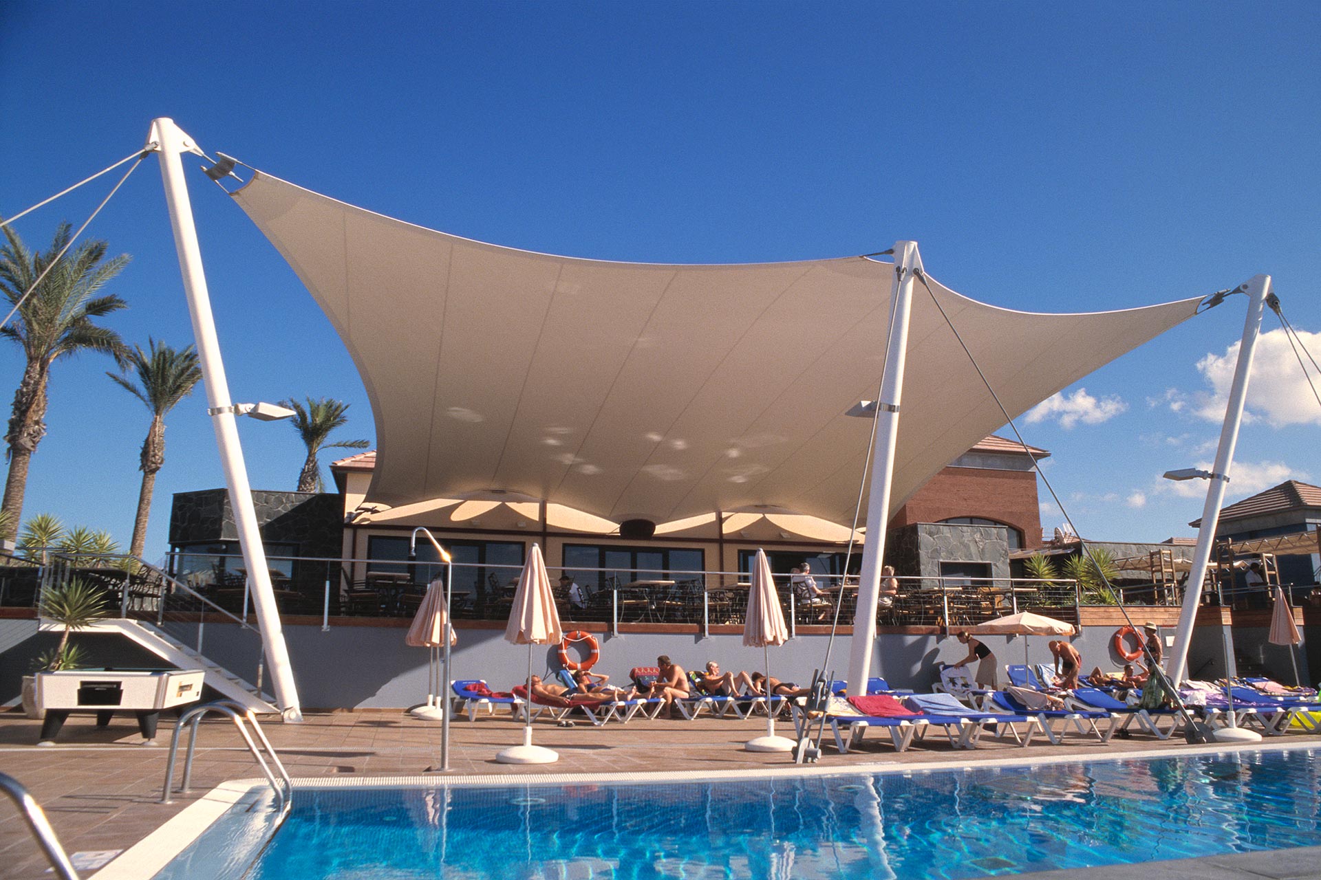 Estructura tensada cubriendo terraza en piscina Cay beach