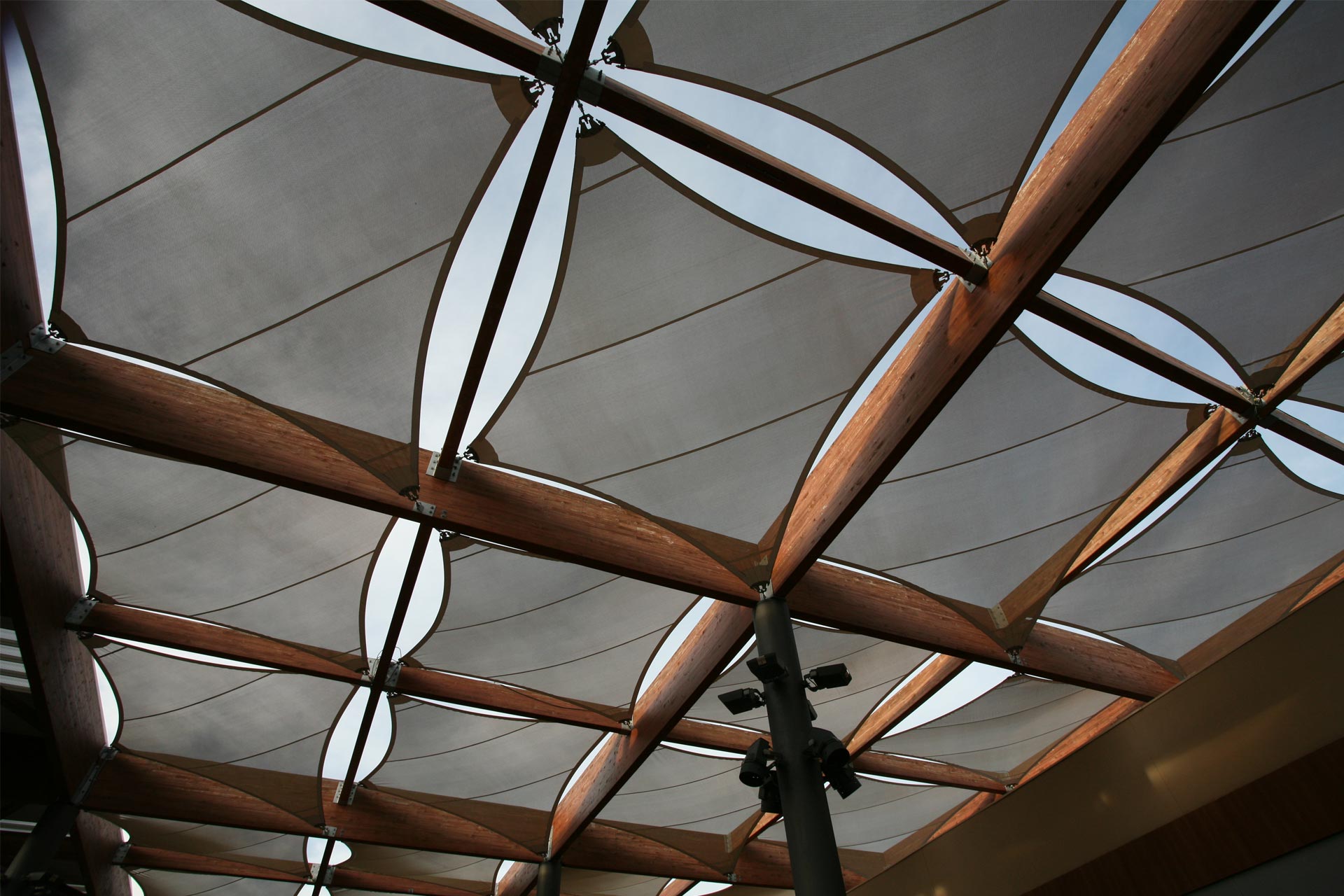 Estructura tensada con módulos en forma de rombo y estructura de madera del centro comercial Thader