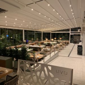 Terrace of an aquipated restaurant with the Nian pergola and with glass screens.