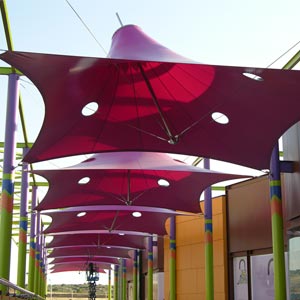 Estructura tensada en forma de parasol de color rojo en centro comercial Puerta toledo