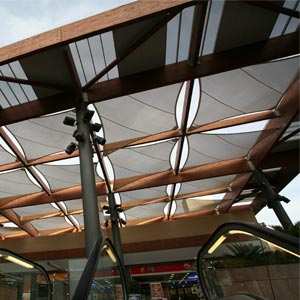 Estructura tensada con módulos en forma de rombo y estructura de madera del centro comercial Thader