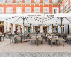 Parasol blanco en terraza restaurante orio en la plaza mayor de Madrid
